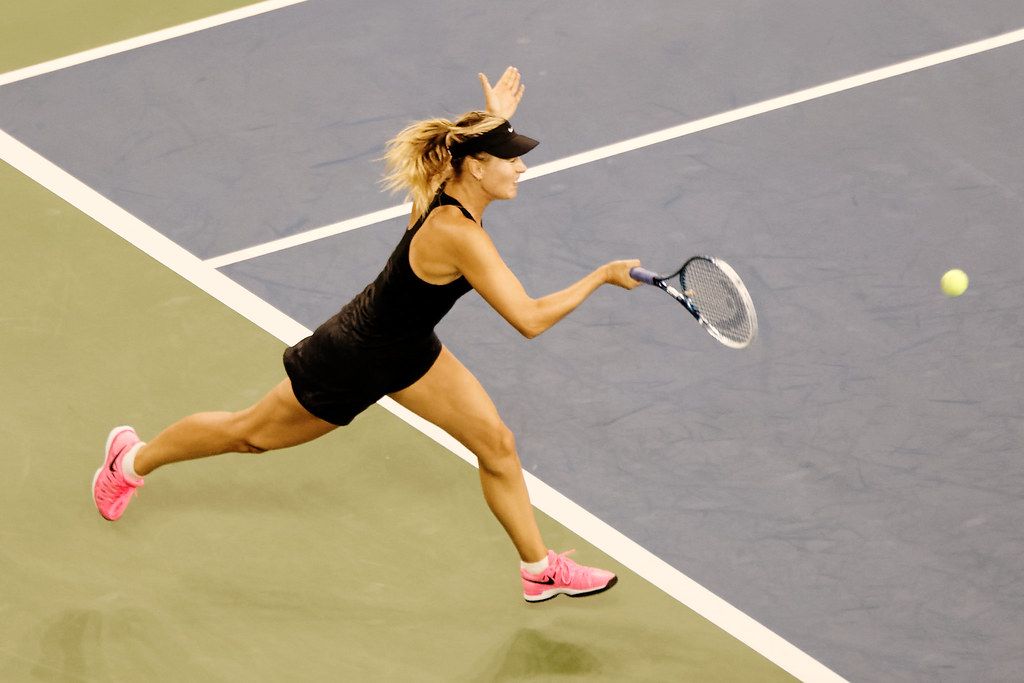 Player chasing a ball on a hard court