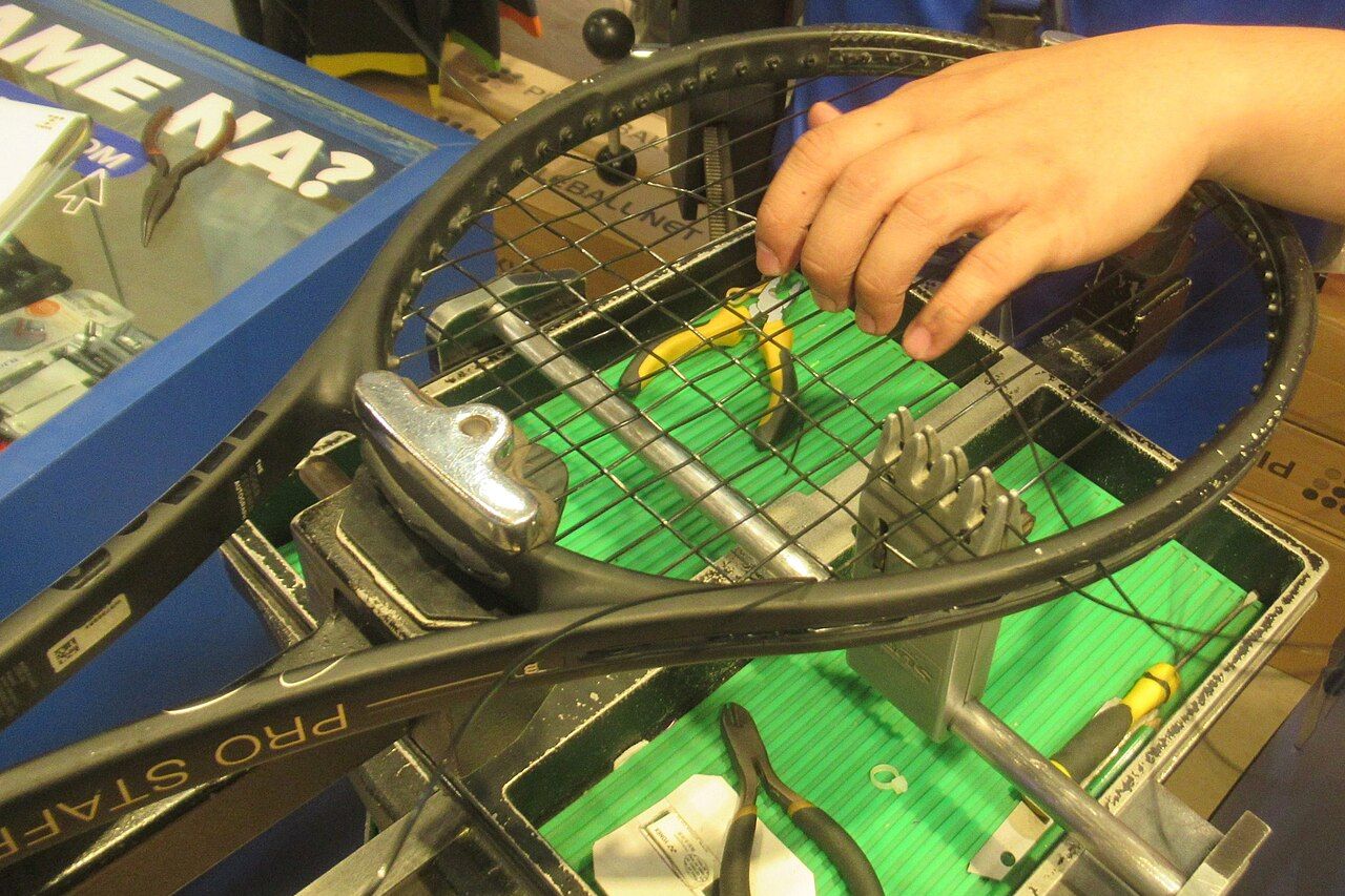 Racquet being restrung on a stringing machine