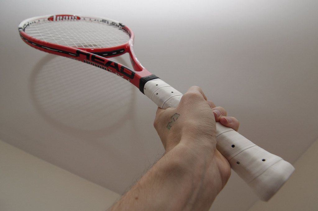 Hand holding the grip of a tennis racquet